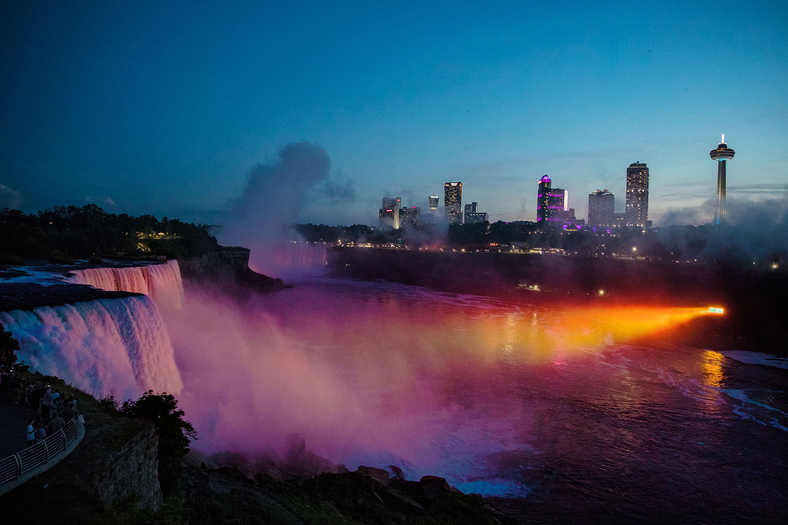 Breathtaking Niagara Falls evening skyline featuring illuminated waterfalls, colorful city lights and spectacular panoramic scenery