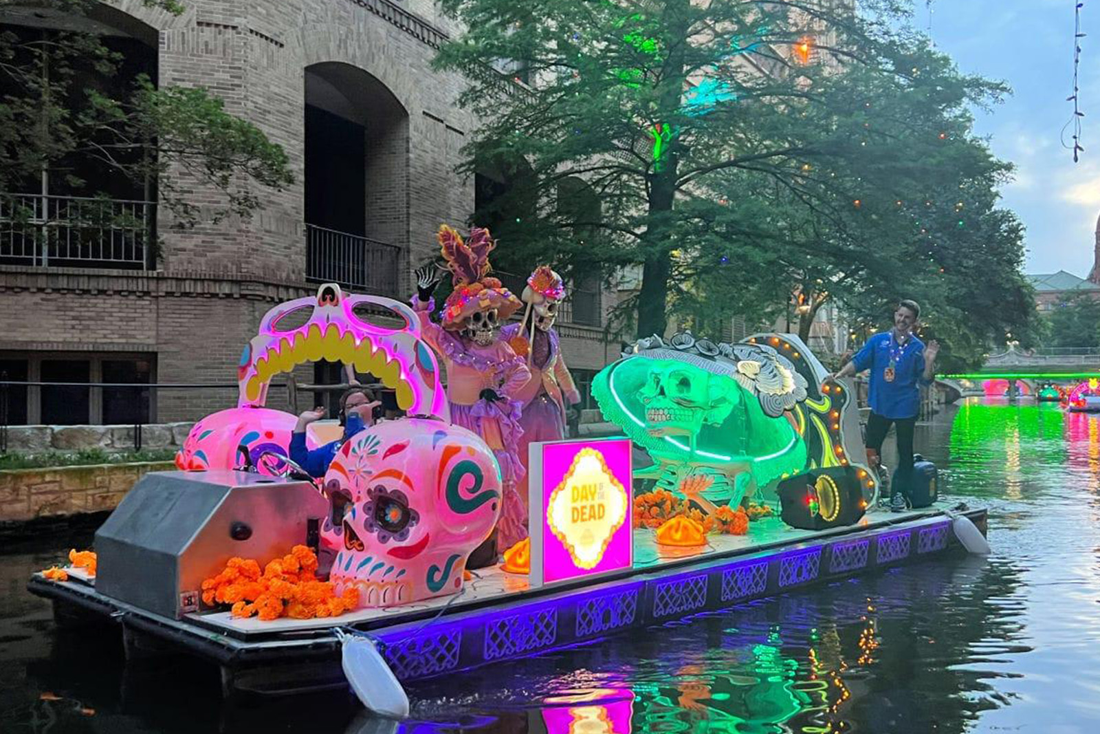 Colorful sightseeing riverboat cruising along the famous San Antonio River Walk surrounded by historic buildings and restaurants