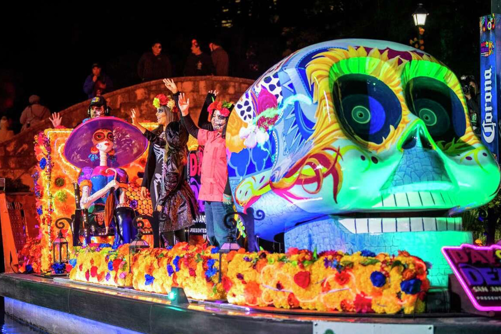 Traditional Dia de Los Muertos ofrenda decorated with orange marigolds, candles, colorful papel picado and remembrance photographs