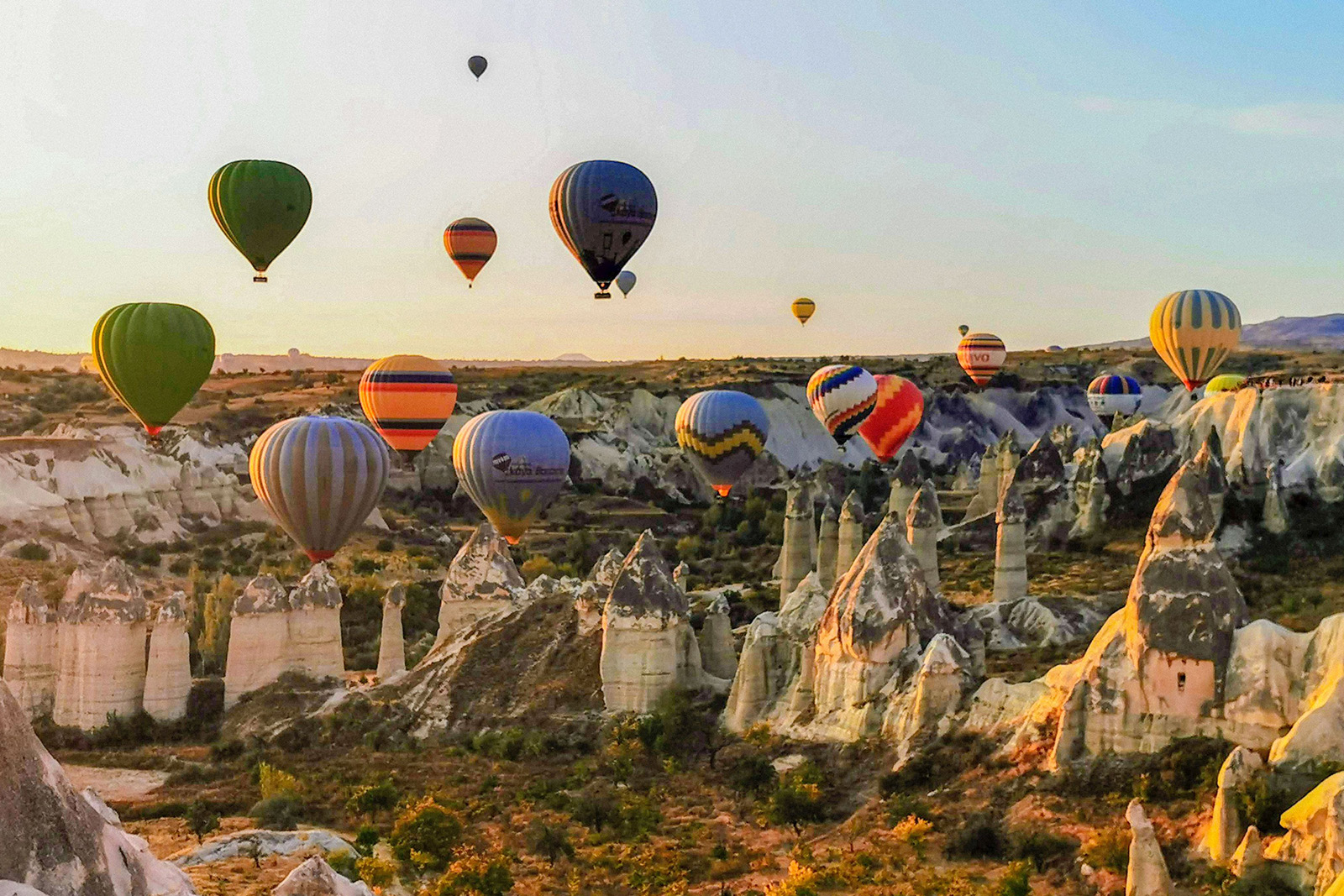 Spectacular Cappadocia fairy chimneys and colorful hot air balloons above volcanic valleys in Turkey