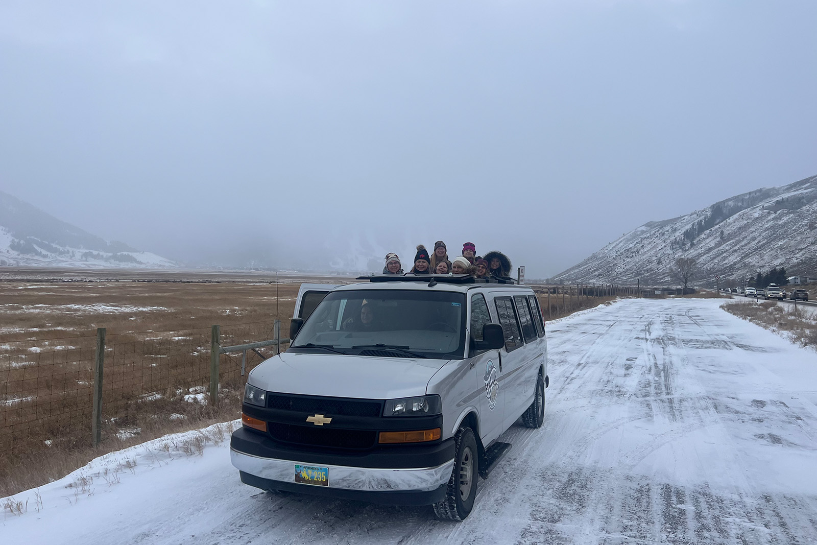 Specialized Yellowstone snowcoach traveling through snow-covered forests and winter wilderness